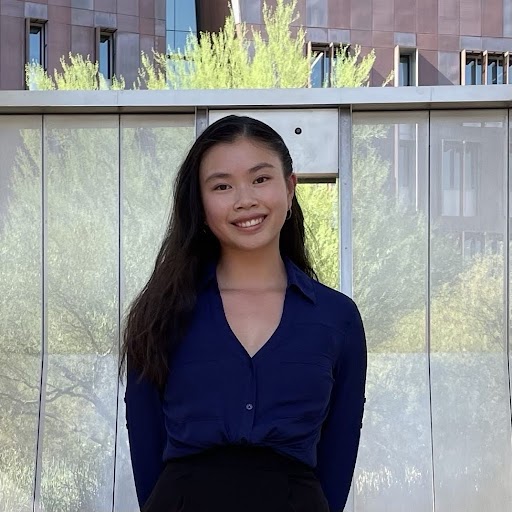 Female student smiling in front of a building