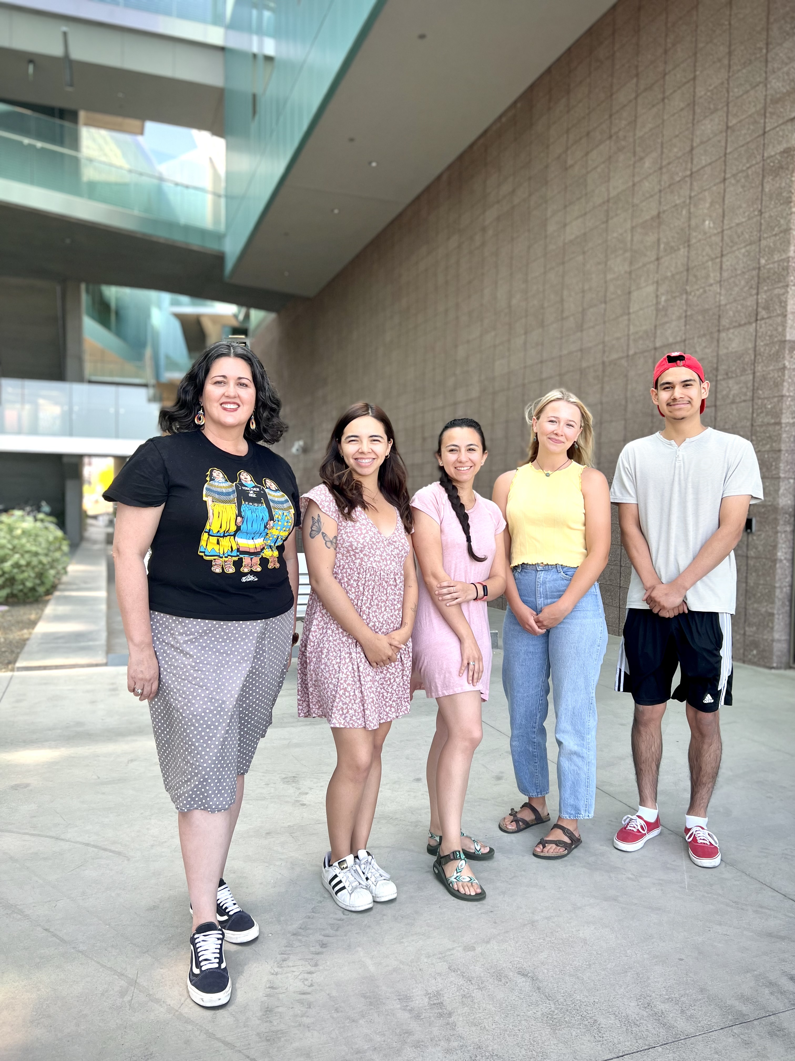 5 students stand together at the ISTB7 Building in front of water pathway.