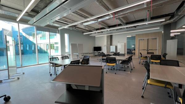 Lab space located in the Walton Center for Planetary Health, shows desks whiteboards and a view of the buildings atrium.